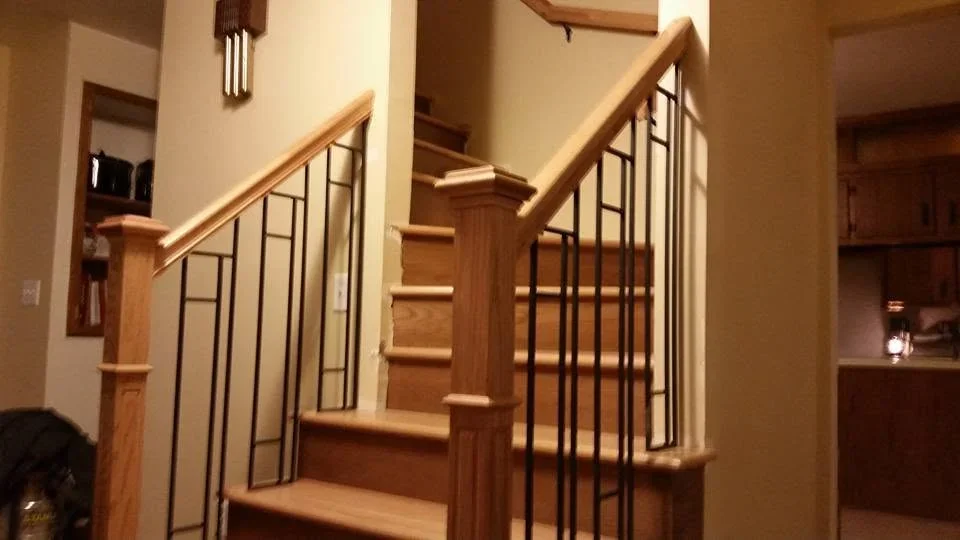 Wooden staircase with metal railing and natural wood handrail