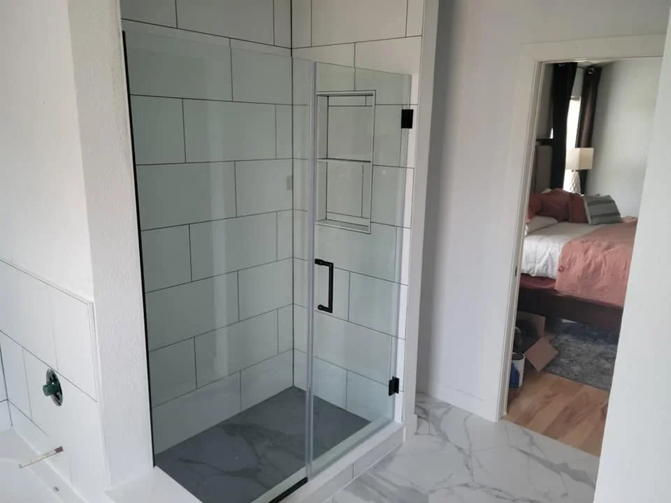 Frameless glass shower enclosure with subway tile walls and slate base