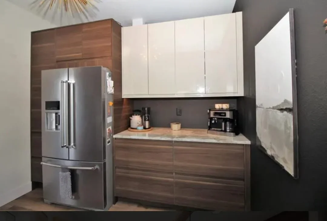 Modern kitchen with white and walnut cabinetry, dark gray backsplash, stainless steel appliances