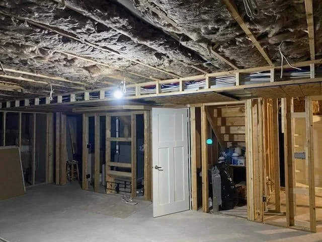 Kitchen framing with wood studs, drywall, door opening, and ceiling mechanical rough-in