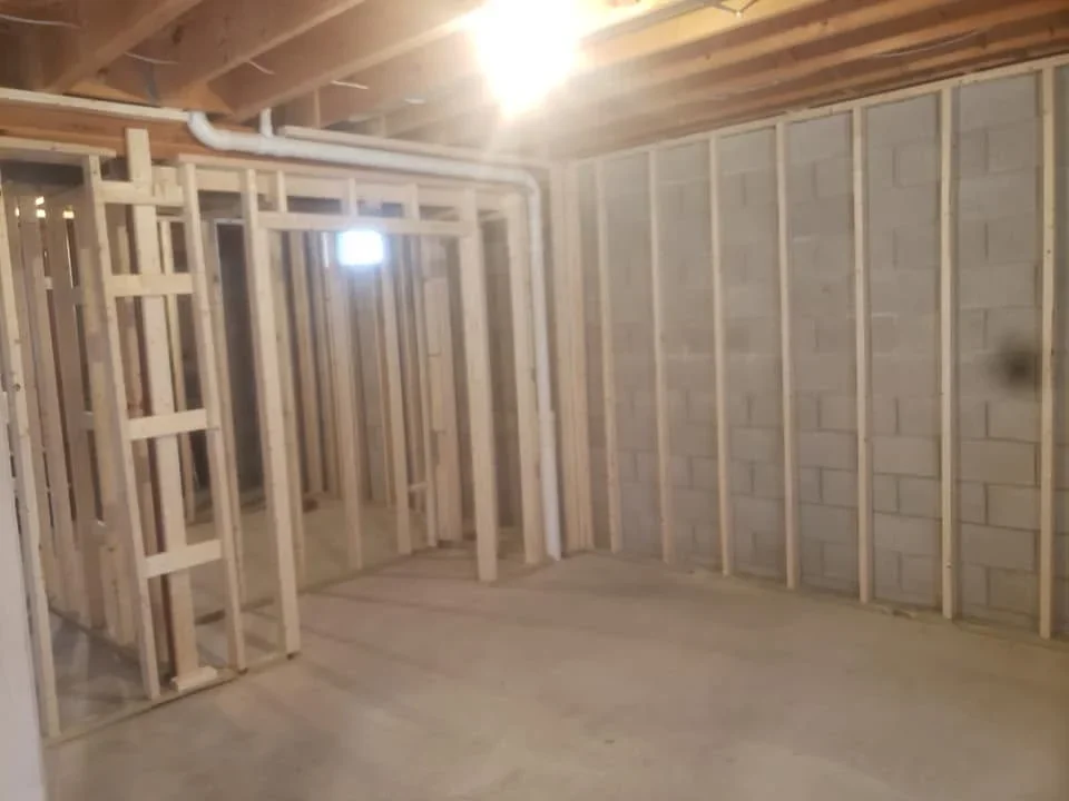Basement with metal stud framing and drywall panels installed on walls and ceiling