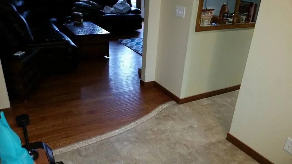 Hardwood and tile flooring with wood trim transitions between rooms