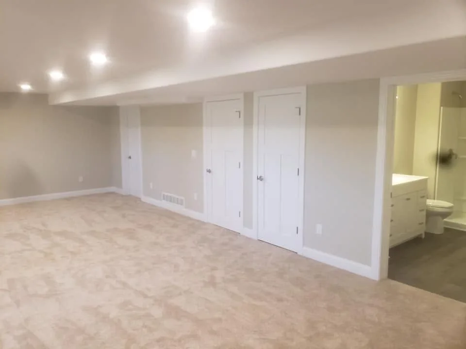 Finished basement with drywall walls, white doors, recessed lighting, and bathroom