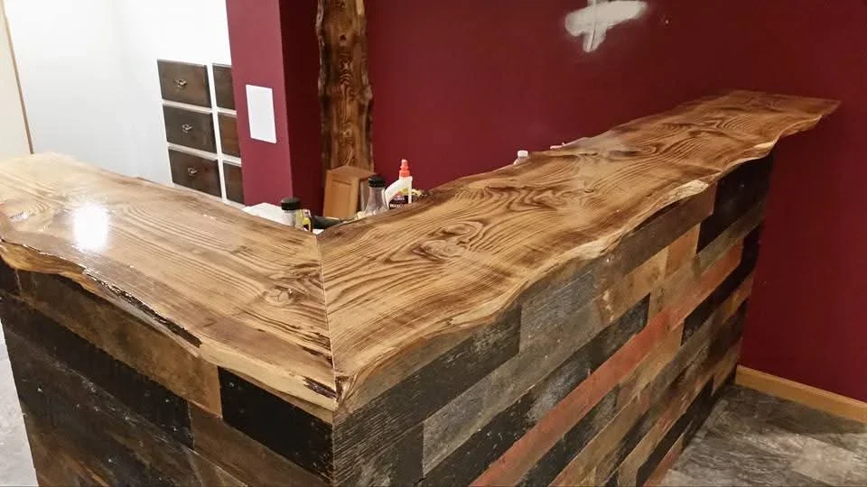 Live edge wood bar counter with natural grain finish and reclaimed wood base
