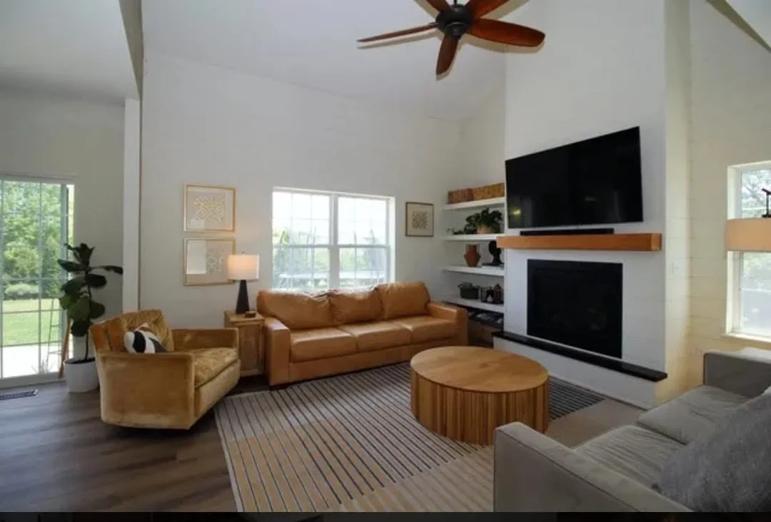Living room with custom wood shelving, fireplace surround, and hardwood flooring