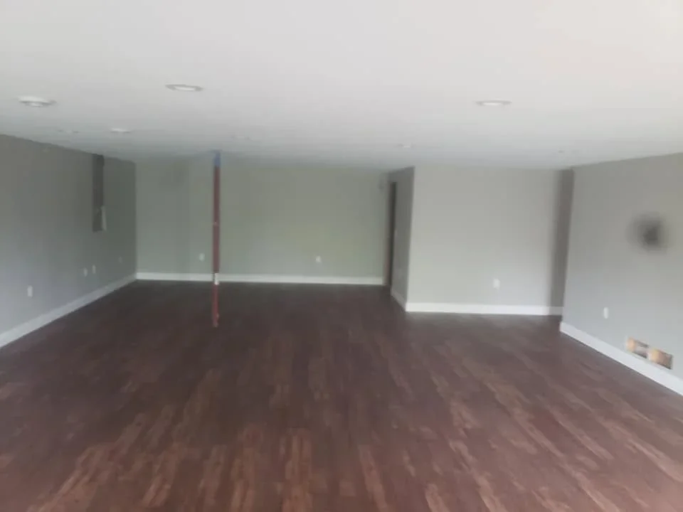 Dark walnut engineered hardwood flooring in finished basement with white drywall walls