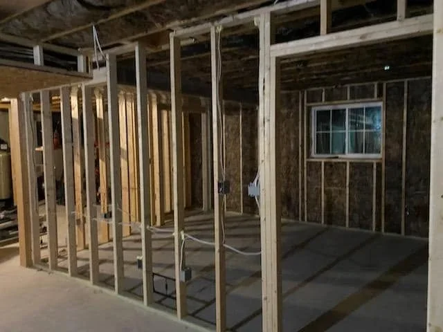 Interior framing with wood studs, drywall, and installed window opening