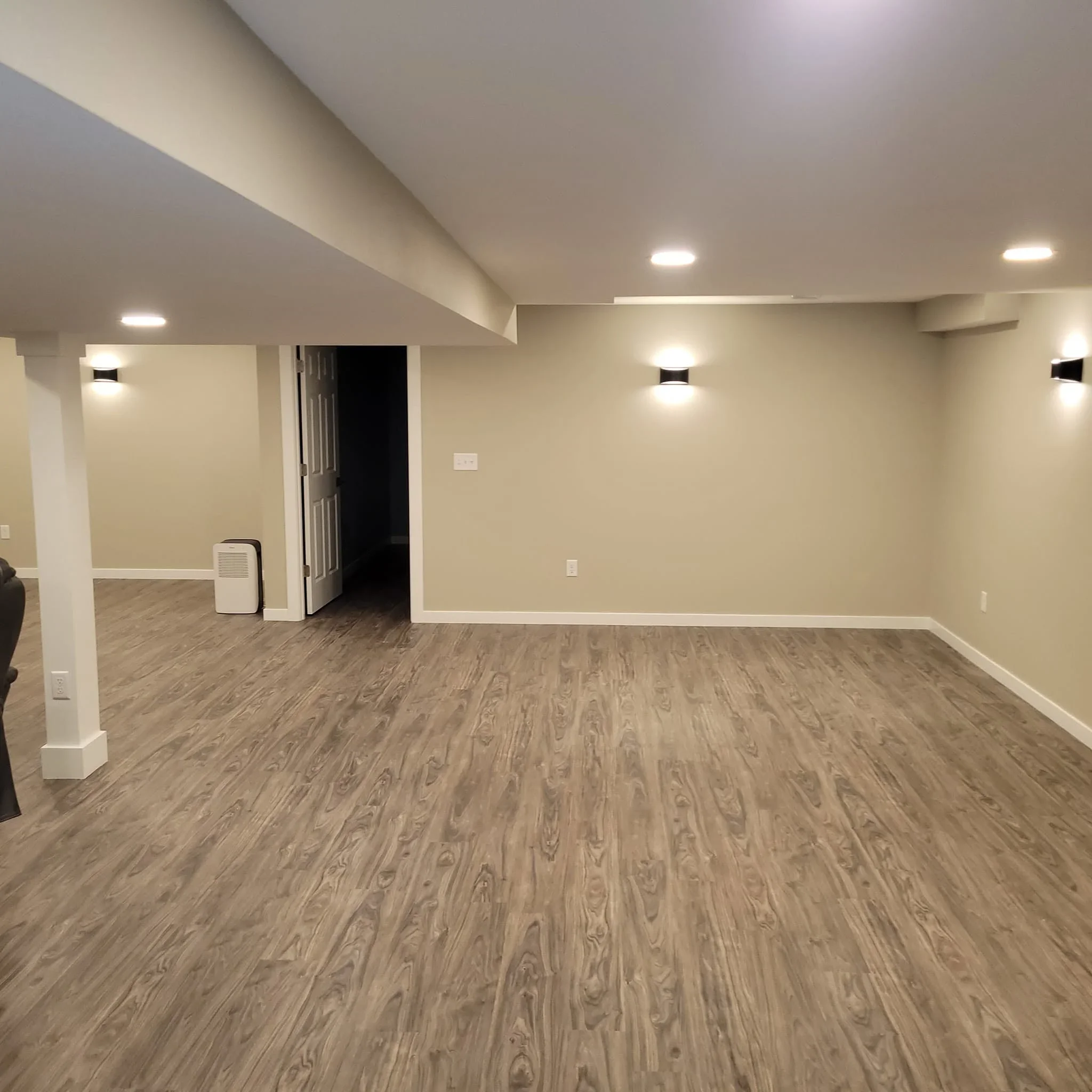 Finished basement with luxury vinyl plank flooring, recessed lighting, and neutral walls