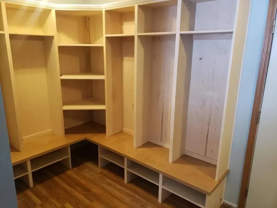 Custom wood walk-in closet with built-in shelves, hanging rods, and storage cubbies