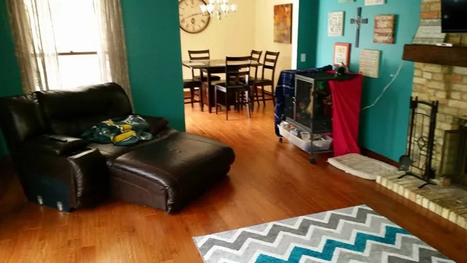 Hardwood flooring installed in open living area with dining table and fireplace